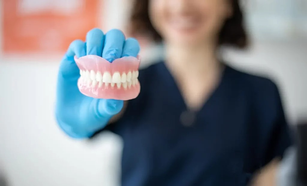 dentist holding a set of dentures